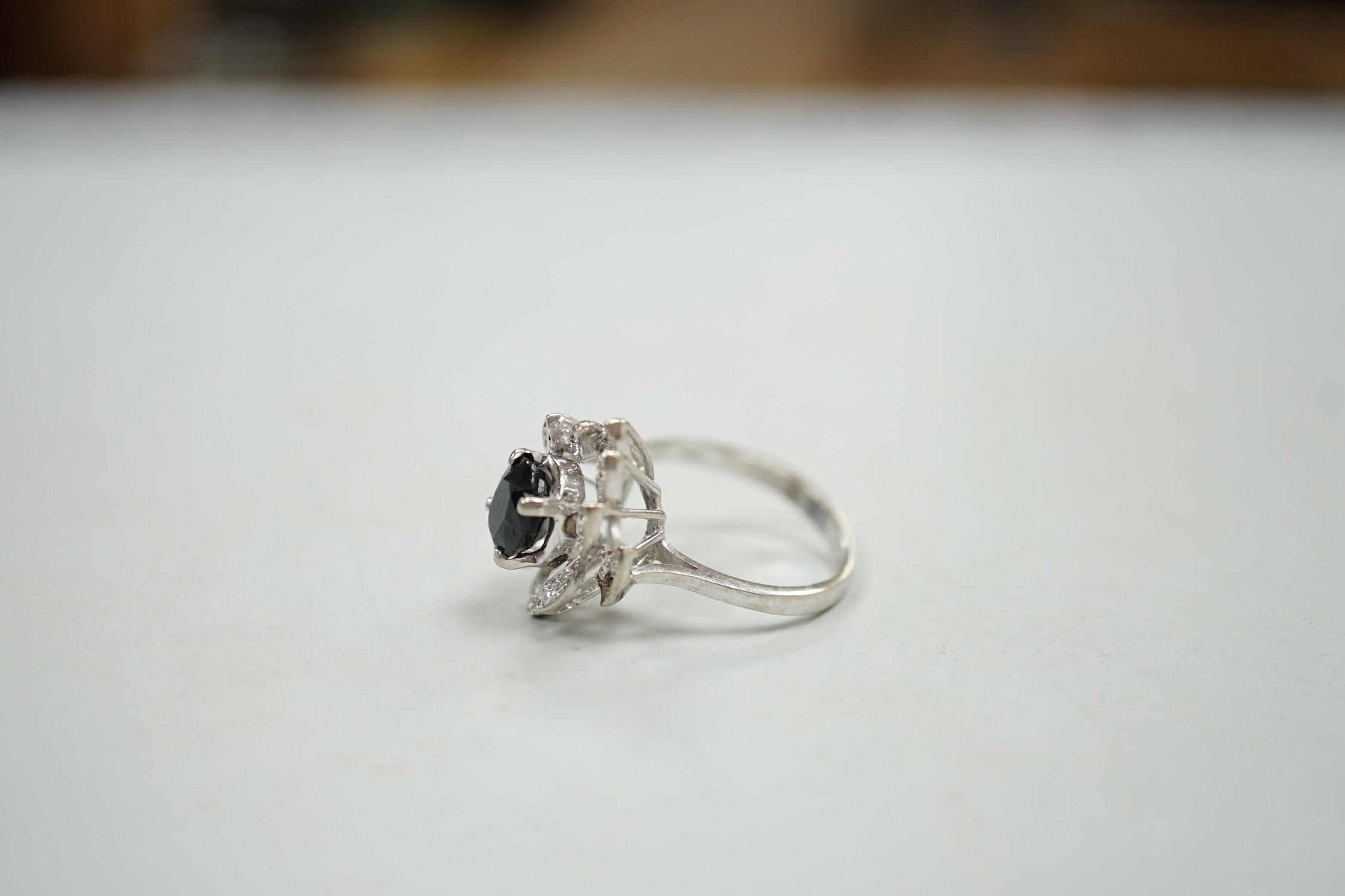 A modern 750 white metal, sapphire and diamond cluster set dress ring (two diamonds missing), size N, gross weight 5.2 grams.